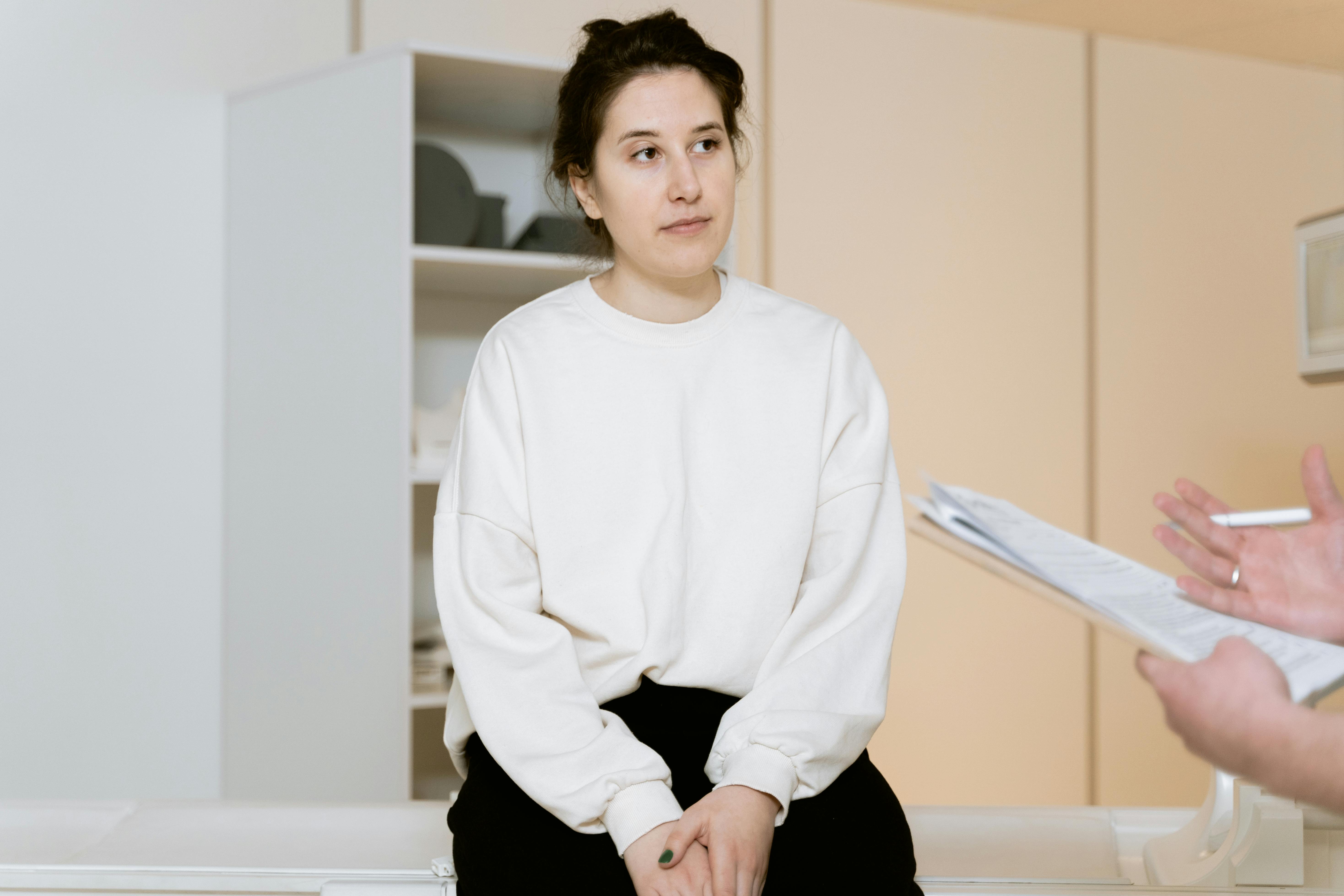 Woman sitting in doctor's office talking with doctor Woman sitting in doctor's office talking with doctor